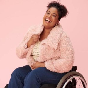 Tatiana Lee in a wheelchair wearing a pink jacket smiling