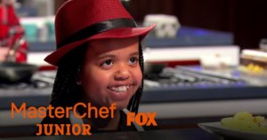 Ivy smiling on MasterChef Junior in the kitchen. Logos for MasterChef Junior and Fox
