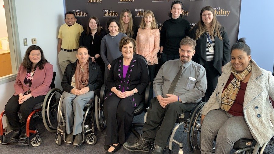 Linda Burger with RespectAbility staff and Fellows in front of the RespectAbility banner