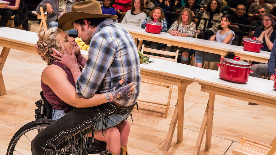 Ali Stroker and James Davis on stage in Oklahoma. Davis is on Stroker's lap.