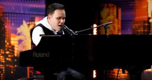 Kodi Lee sitting behind the piano on stage on America's Got Talent, singing