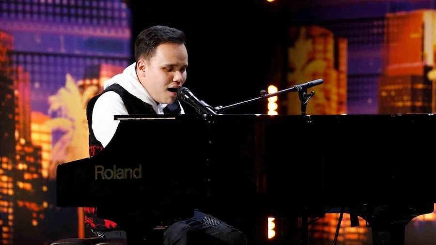 Kodi Lee sitting behind the piano on stage on America's Got Talent, singing