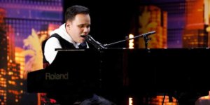 Kodi Lee sitting behind the piano on stage on America's Got Talent, singing