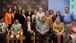 Neil Romano with RespectAbility staff and Fellows in front of the RespectAbility banner