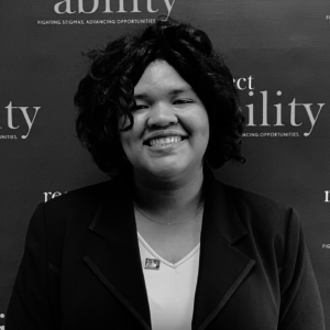 Angelica Vega smiling in front of the RespectAbility banner