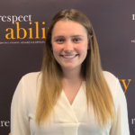 Molly McConville smiling in front of the RespectAbility banner