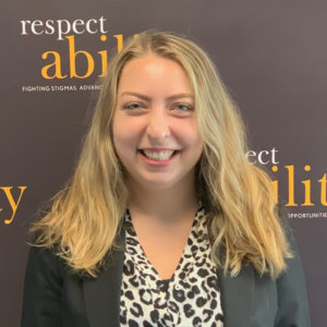 Sarah Meehan smiling in front of the RespectAbility banner