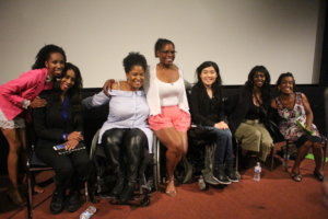 Six women of color with disabilities at the Women of Color Disability Summit on stage together, smiling