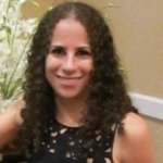 Sharon Rosenblatt smiling in front of green flowers