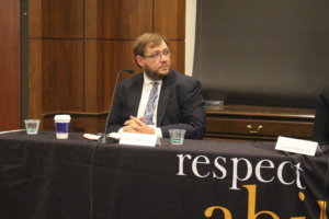 Philip sitting behind a table, participating in RespectAbility's final panel of the 2019 Summit