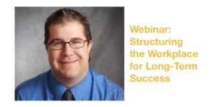 James Emmett smiling wearing a blue shirt and glasses in front of a grey backdrop. Text: Webinar: Structuring the Workplace for Long-Term Success