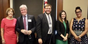 Policy panelists smiling together in front of an American flag at RespectAbility's 2019 summit