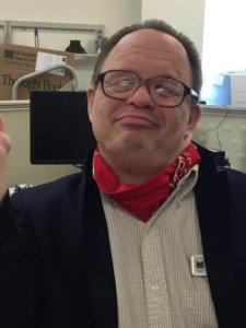 Doug Jarett smiling wearing a red bandana around his neck.