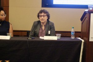 Ila Eckhoff speaking with Evelyn Kelly looking at her, both sitting behind a table