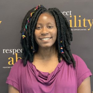 Courtney Murray smiling in front of the RespectAbility banner