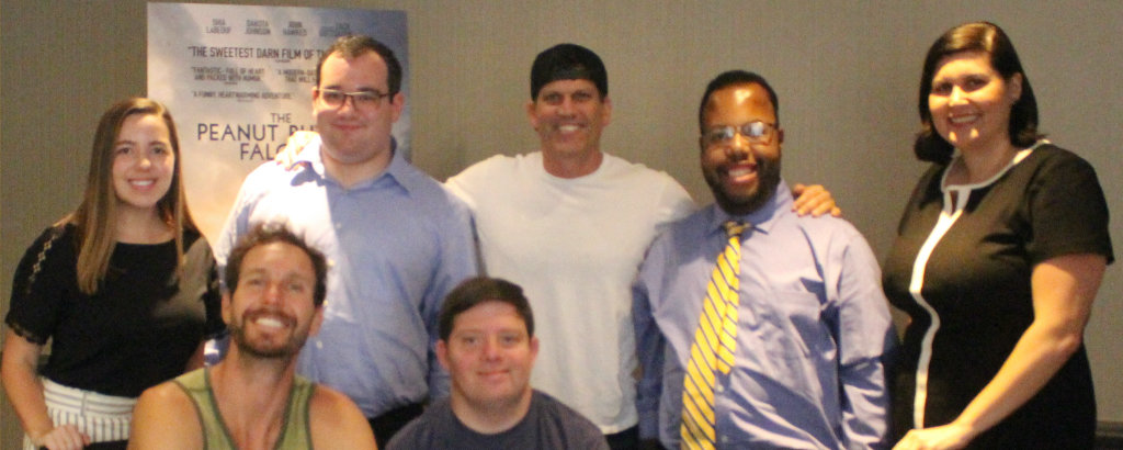 Jolie Carr with RespectAbility team members and the directors and star of the Peanut Butter Falcon in front of a poster for the movie