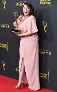 Rachel Bloom holding an Emmy statue on the red carpet, smiling