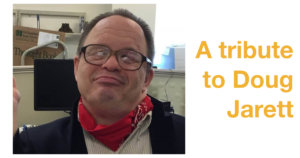 Doug Jarett smiling wearing a red bandana around his neck. Text: A tribute to Doug Jarett