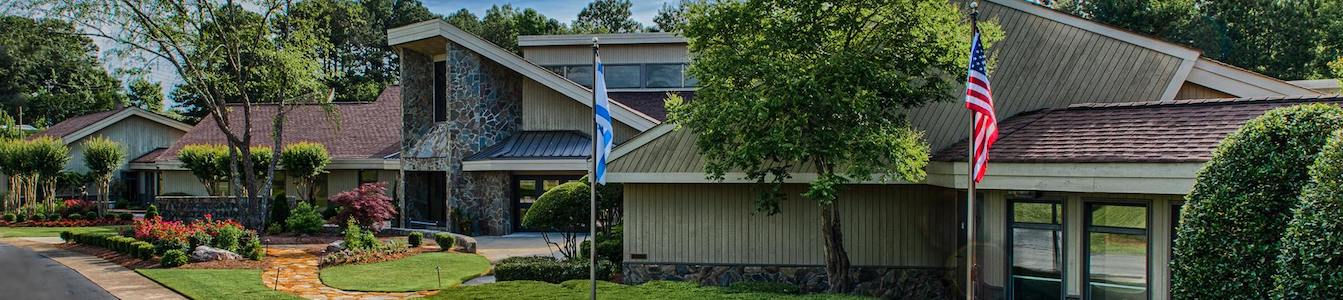 Outside of Congregation Etz Chaim synagogue with an American flag and Israeli flag and plants and trees