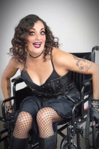 Filmmaker Diana Romero dressed in black, smiling. Romero is a wheelchair user