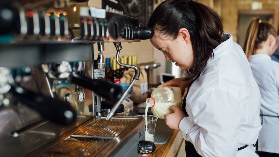 A woman with a disability making coffee at 321 Coffee.
