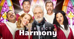 The cast of NBC's Perfect Harmony in red robes inside a church with stain glass windows. Logo for Perfect Harmony