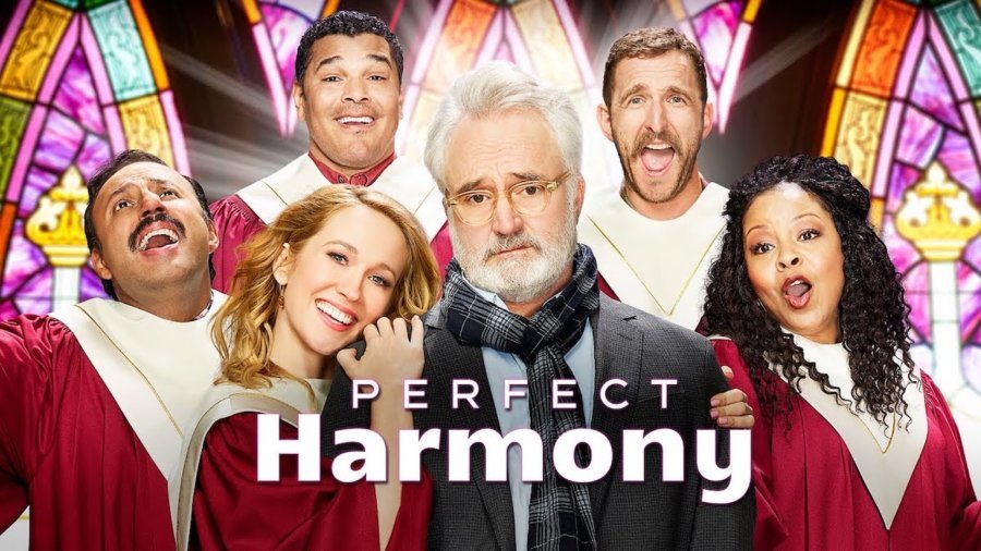 The cast of NBC's Perfect Harmony in red robes inside a church with stain glass windows. Logo for Perfect Harmony