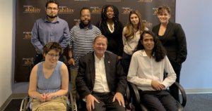 Rep. Steve Bartlett with RespectAbility Fall 2019 Fellows smiling in front of the RespectAbility banner