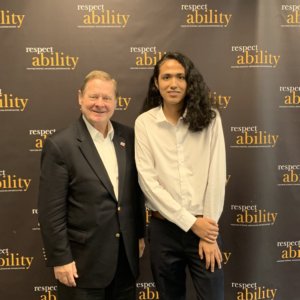 Steve Bartlett and Bruno Medina smiling in front of the RespectAbility banner