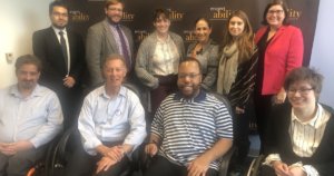 Larry Lipman with RespectAbility staff and Fellows in front of the RespectAbility banner, all smiling