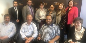 Larry Lipman with RespectAbility staff and Fellows in front of the RespectAbility banner, all smiling