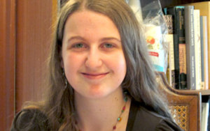 Rachel Chabin smiling headshot sitting in front of a bookshelf