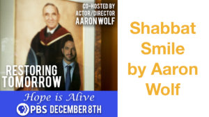 Text: Shabbat Smile by Aaron Wolf Co-hosted by Actor/Director Aaron Wolf Restoring Tomorrow Hope is Alive PBS December 8th. A portrait in an art gallery with a man reflected in the glass