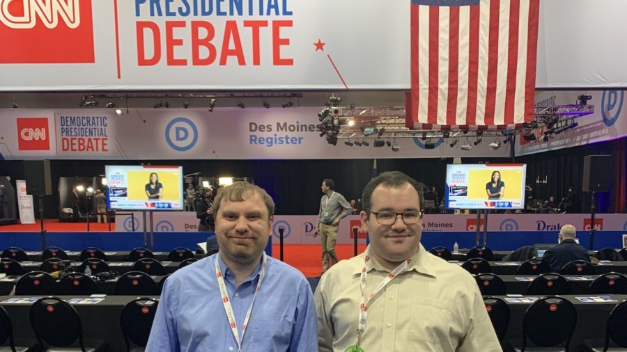 James Trout and Eric Ascher smile inside the spin room at the CNN Democratic Debate
