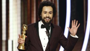 Ramy Youssef on stage at the 77th Annual Golden Globes Award speaking with his award for Best Actor in his hand