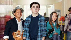 three pre-teens, one girl in a wheelchair, and two boys standing, and a dog posing