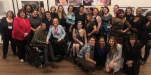 Women with disabilities smile together inside Positive Exposure's art gallery in New York City