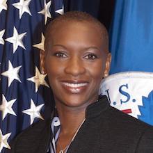 Claudia Gordon smiling in front of an American flag