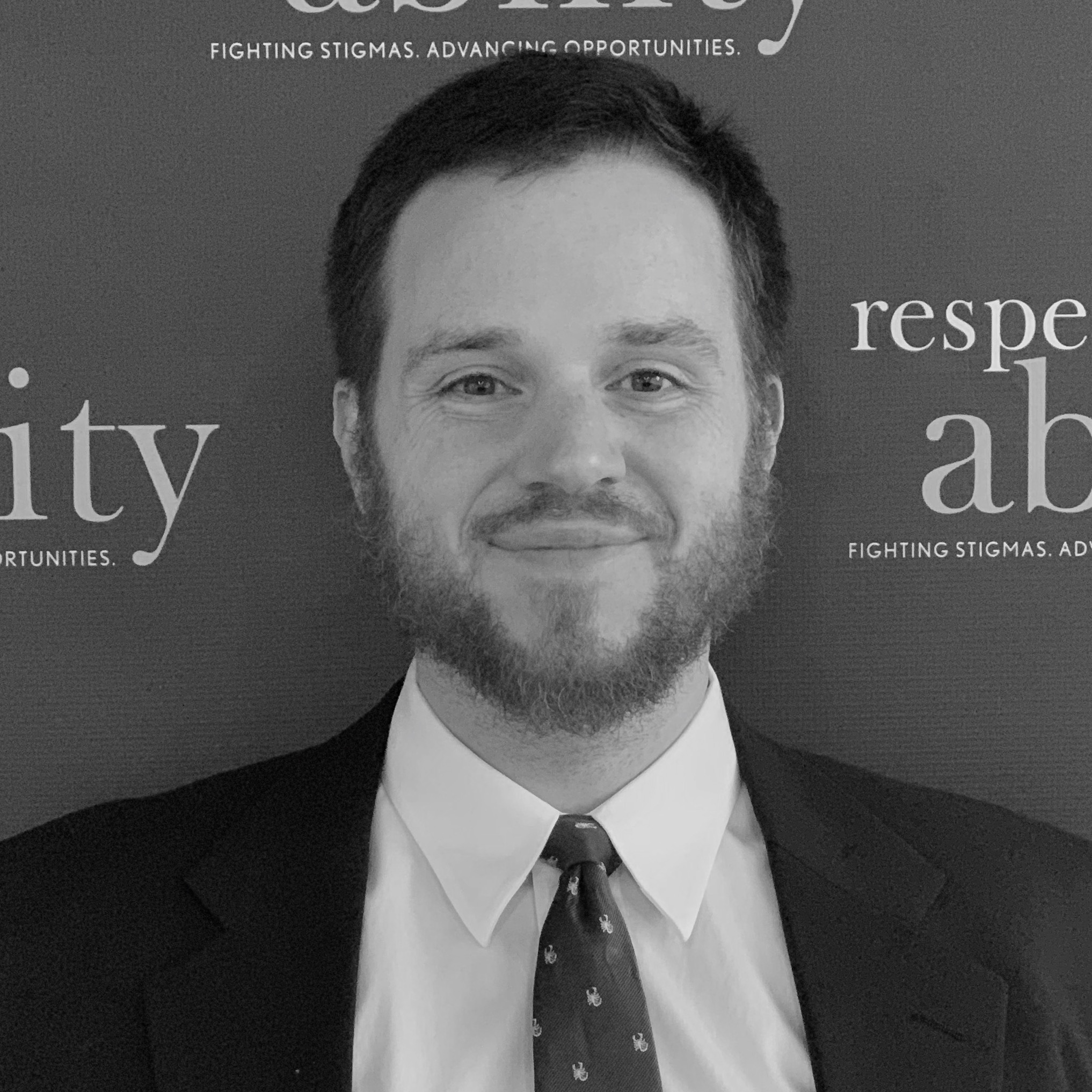 Geoff Hoppe smiling in front of the RespectAbility banner