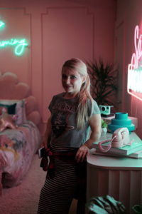 Ashley Eakin smiling on the set of a film shoot in a child's bedroom
