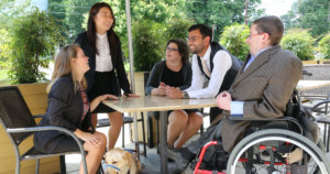 RespectAbility Fellows with disabilities around a table outside, having a conversation