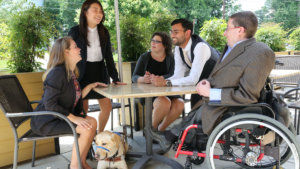 RespectAbility Fellows with disabilities around a table outside, having a conversation