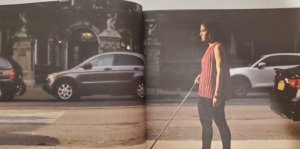 Magazine spread of Khadija Bari walking down a street holding a white cane