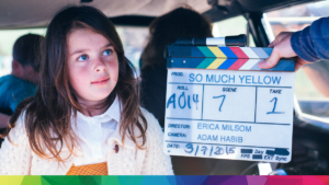 Photo from set of So Much Yellow with a young girl next to a film clapper