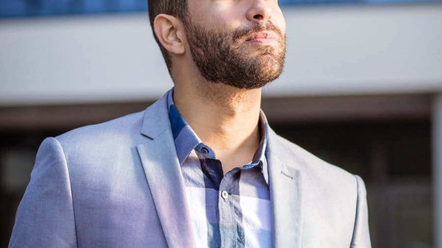 Andrew Reid headshot in front of a tall building