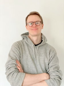 Andrew Fisher smiling headshot wearing a sweatshirt