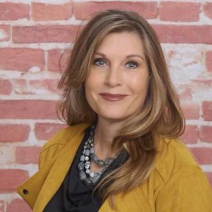 Carla Boyd smiling headshot in front of a brick wall