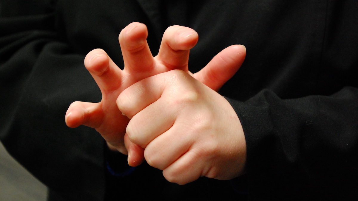 The American Sign Language word for COVID-19 mimics the virus' appearance, with fingers forming the spikes, or coronas, the virus is known for. Photo credit: NCDHHS.