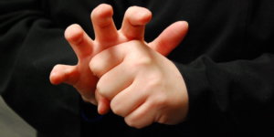 The American Sign Language word for COVID-19 mimics the virus' appearance, with fingers forming the spikes, or coronas, the virus is known for. Photo credit: NCDHHS.