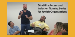 A man using a wheelchair next to an ASL interpreter speaks as three other people look on seated. Text: Disability Access and Inclusion Training Series for Jewish Organizations